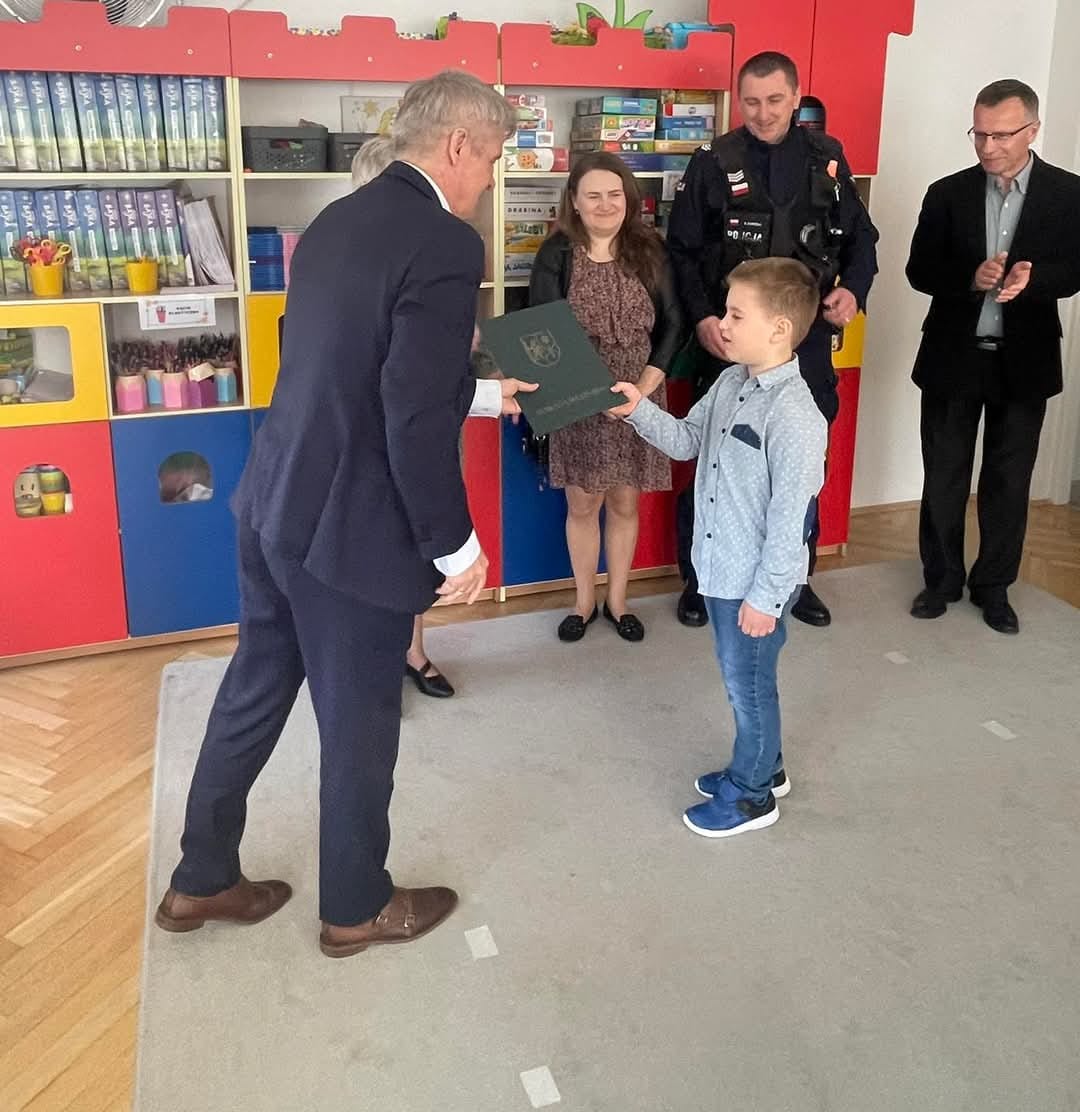 policjant z rodzina uczestniczą w spotkaniu odebranie podziękowań dla synka