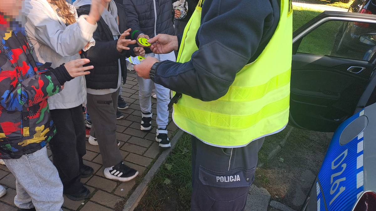 policjant rozdaje odblaski