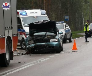 miejsce kolizji drogowej, pojazdy straży pożarnej, policji, pogotowia, umundurowana policjantka i rozbite Audi