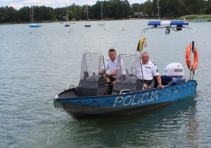 Zdjęcie poglądowe policjantów na łodzi policyjnej. Łódź znajduje się na tafli jeziora