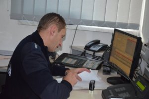 policjant na stanowisku kierowania rozmawiający przez telefon