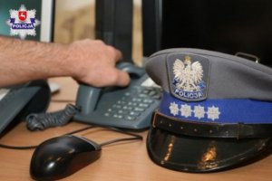 czapka policyjna obok telefonu