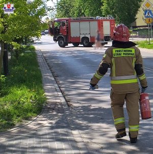 strażak podczas akcji, idzie trzymając gaśnicę