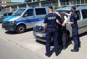 policjanci prowadzą osobę zatrzymaną