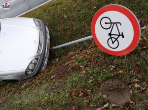 auto w rowie i przewrócony znak