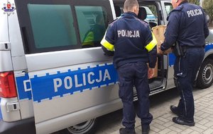 policjanci pakują dary do radiowozu