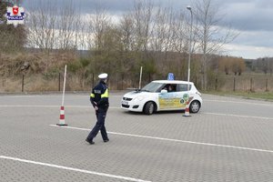 policjant na torze jazdy obok uczestnik w aucie