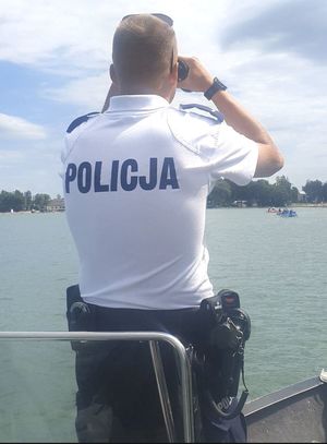 Zdjęcie poglądowe policjanta patrzącego przez lornetkę