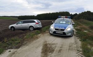 Zdjęcie zabezpieczonego samochodu marki Opel stojącego w polu po prawej stronie samochód oznakowany policji