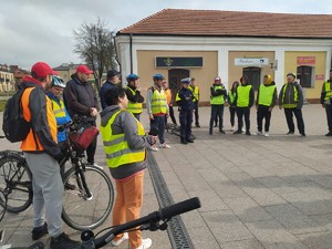 Zdjęcie policjantki ruchu drogowego omawiającej zagadnienie z uczestnikami rajdu rowerowego