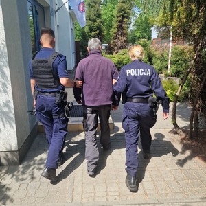 Zdjęcie policjantów prowadzących zatrzymanego