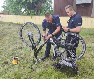 Dwóch policjantów podczas znakowania roweru