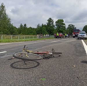 Rower leżący na drodze. W tle radiowóz