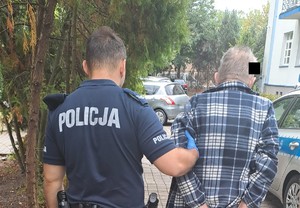 policjant prowadzi zatrzymanego