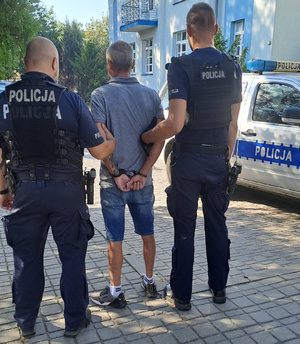 policjanci prowadzą zatrzymanego