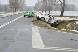 zdarzenie drogowe z udziałem 2 aut. Kia koloru białego z uszkodzeniami  znajduje się obrócone bokiem w rowie, audi widok z tyłu