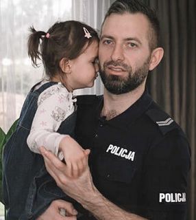 policjant trzyma na rękach dziewczynkę