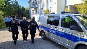 policjanci prowadzą zatrzymanego