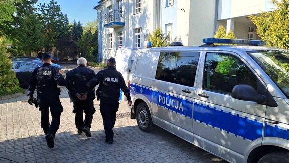 policjanci prowadzą zatrzymanego