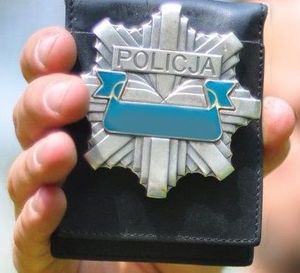 trzymana w ręku policyjna odznaka
