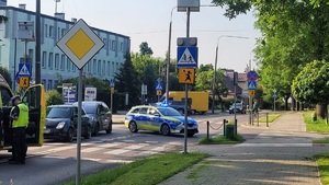 Miejsce potrącenia rowerzystki na przejeździe dla rowerów we Włodawie przy ulicy Piłsudskiego. Na zdjęciu widoczne są samochody policji, pogotowia, dwa ciemne pojazdy osobowe, oraz umundurowani policjanci