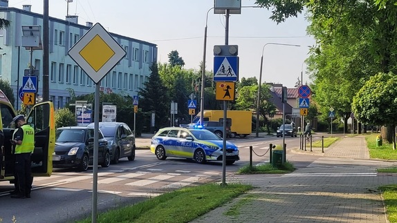 Miejsce potrącenia rowerzystki na przejeździe dla rowerów we Włodawie przy ulicy Piłsudskiego. Na zdjęciu widoczne są samochody policji, pogotowia, dwa ciemne pojazdy osobowe, oraz umundurowani policjanci