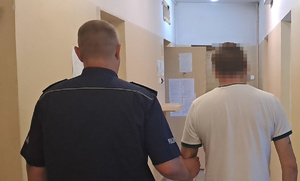policjant trzyma zatrzymanego w PDOZ