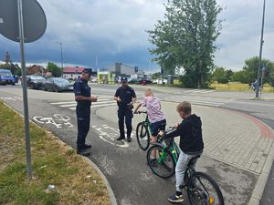 policjanci wręczają dzieciom ulotki