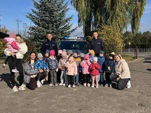 dzieci i policjanci w tle radiowóz