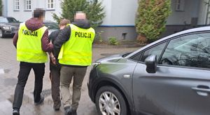 policjanci prowadzą zatrzymanego