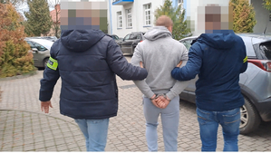 policjanci doprowadzają zatrzymanego