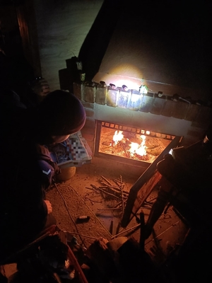 Zdjęcie przedstawiające policjanta rozpalającego w kominku