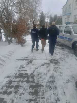 Zdjecie przedstawiające policjantów doprowadzających zatrzymanego na przesłuchanie