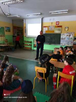 zdjęcie przedstawiające policjanta w trakcie prowadzeniA PRELEKCJI O BEZPIECZNYCH FERIACH