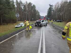 zdjęcie przedstawiające miejsce zdarzenia( dwa rozbite pojazdy) oraz interweniujące służby