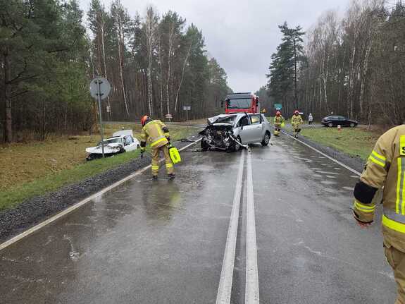 zdjęcie przedstawiające miejsce zdarzenia( dwa rozbite pojazdy) oraz interweniujące służby