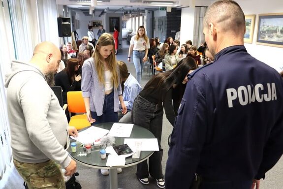 Policjanci na konkursie czytelniczym pokazują wybrane techniki kryminalistyczne