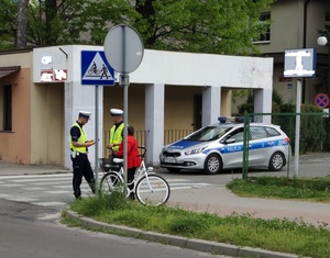 Zdjęcie przedstawiające 2 policjantów podczas kontroli rowerzysty w rejonie przejścia dla pieszych i przejazdu rowerowego