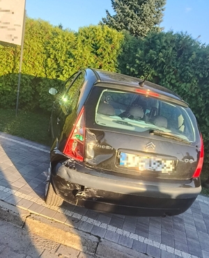 zdjęcie przedstawia zaparkowane auto z uszkodzonym tyłem