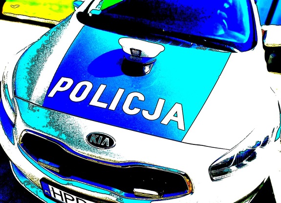 radiowóz policyjny oznakowany, na którym na masce leży czapka policyjna