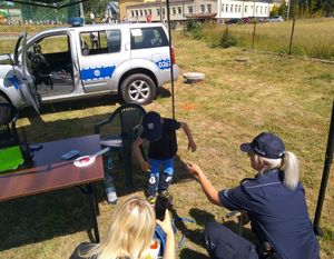 policajntka na policyjnym stoisku z uczestnikami festynu